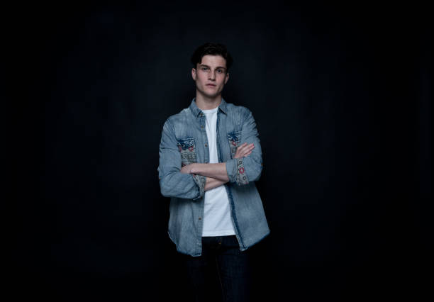 istock Good looking man wearing a button down shirt in front of black background 1160635368