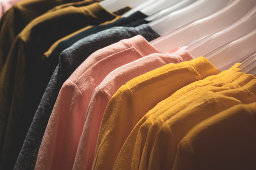 Camisetas coloridas en una percha en la tienda de moda photo