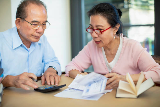 istock Senior couple working with bills at table 1160636404