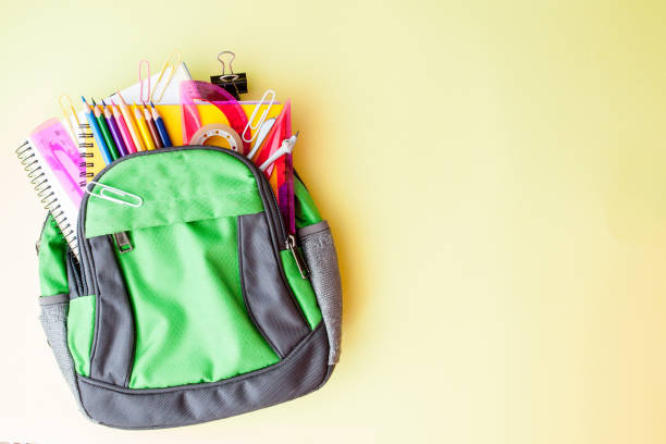 istock Flat lay composition with backpack and school stationery on yellow background 1160636577
