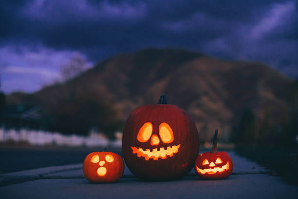 istock Jack o' Lanterns on Neighborhood Sidewalk at Dusk 1160636891