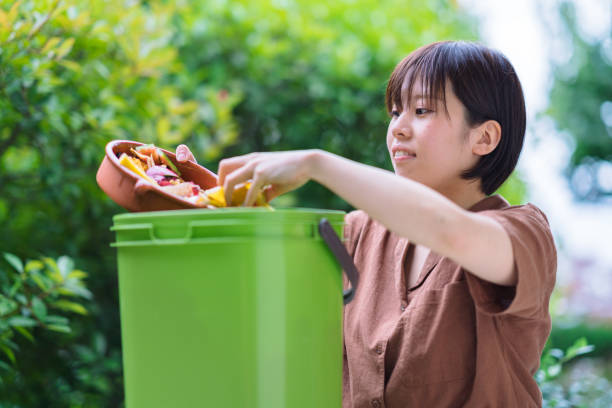 istock Woman putting food garbage into composter 1160637564