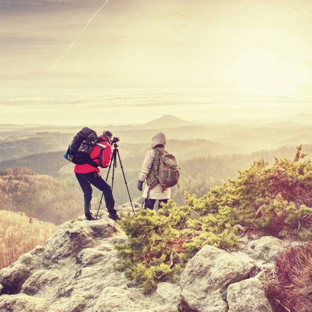 istock Man and girlfriend shooting sunset on the top mountain 1160638750