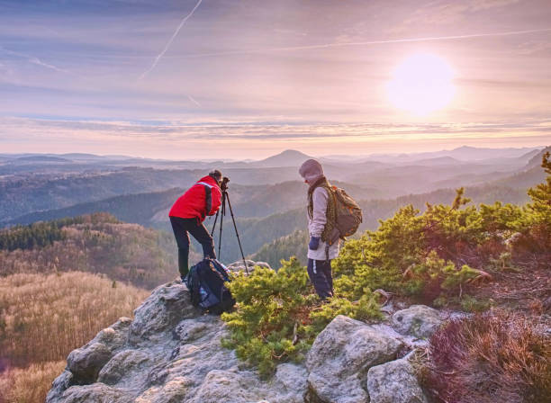 istock Two people stay at  tripod on background of a mountain range 1160638774