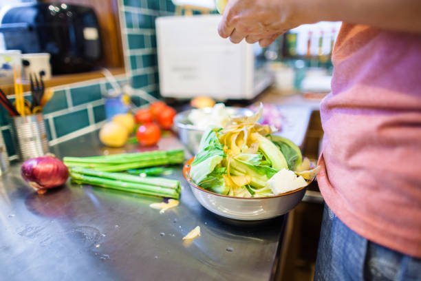 A man is preparing food left over for composting.\n\nThey are using pineapple, mango, grapefruit, orange, apple, lemon, kiwi, watermelon, lime, paprika, beans, eggplant, onion, cucumber, avocado, tomato, zucchini, lettuce, potato, sweet corn, sweet potato, green pepper, garlic, ginger, turmeric, cumin, almond, cashew nuts, walnut, raisins, banana chips, coconut milk, olive oil, pasta, macaroni, brown rice, bread.