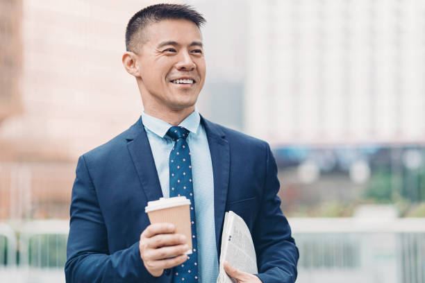 istock Smiling businessman with coffee and newspaper 1160639982