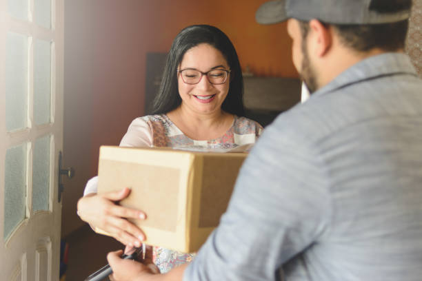 istock Woman receiving a package at home from delivery man 1160640630