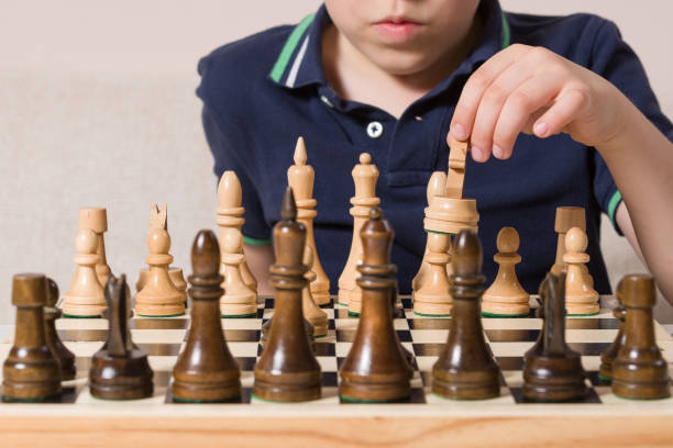 istock Closeup of child's hand with chessboard. Boy playing chess. 1160640730
