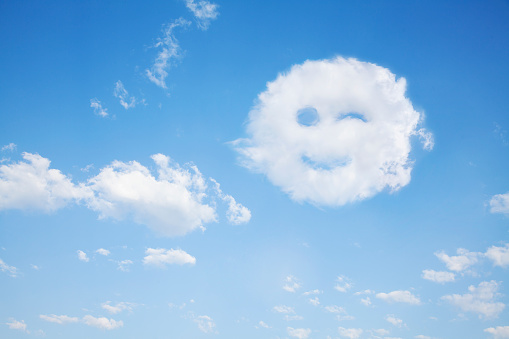 Smiling winking cloud in blue sky