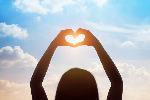 istock Woman making a heart symbol with her hands in clouds 1160646235