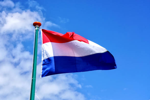 istock Dutch flag against blue sky background 1160646512