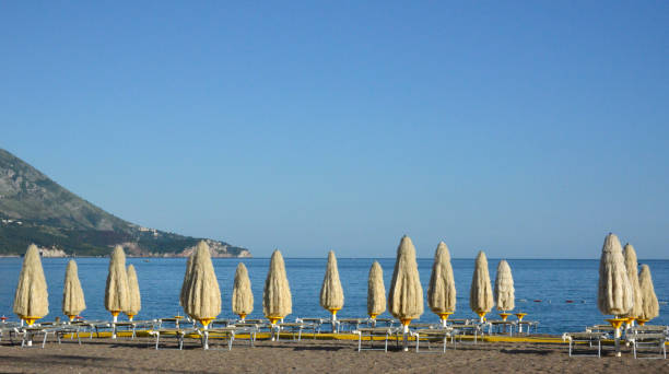 istock Parasols, deck chairs and yellow footpath on the sandy beach 1160647408