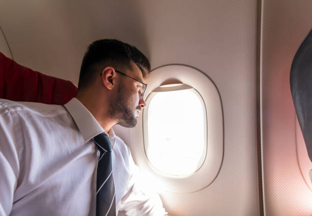 istock Businessman looking out airplane window 1160650057