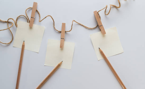 istock brown paper hung with clothspins on white background 1160654829