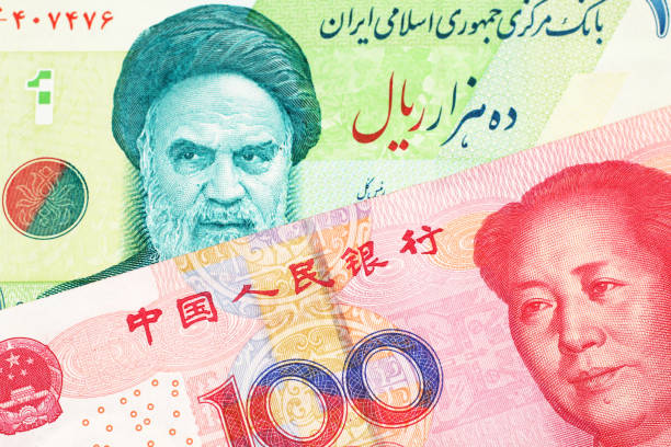 An Iranian rial bill with Chinese money stock photo
