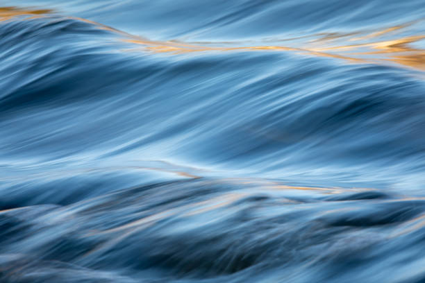 Water in a river Water concept - river water flowing with light reflecting of its surface - long exposure shot fast water stock pictures, royalty-free photos & images