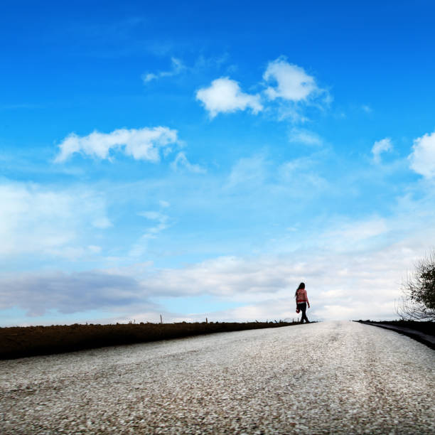 empty road and young adult woman on countryside landscape