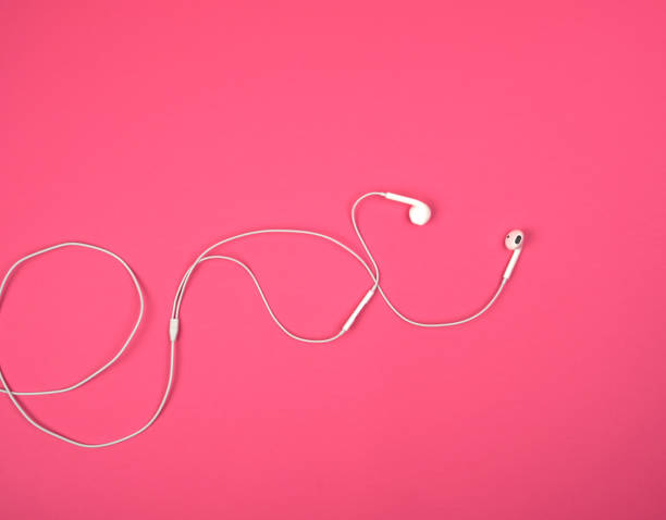istock white headphones with a cable on a pink background 1160658905