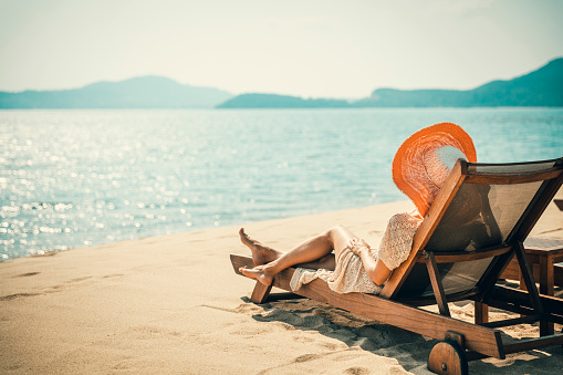 Middle aged woman resting on the beach. Disconnect from work. Reduce stress. Recharging batteries.