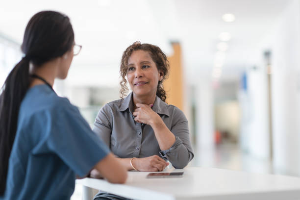 Woman meets with her female physician A female doctor of Middle Eastern ethnicity is meeting with her female patient. The patient is a mature adult woman of African descent. The two women are seated at a table. The doctor has a digital tablet. They are discussing a treatment plan for the patient's illness. The doctor has her back to the camera. medical insurance data stock pictures, royalty-free photos & images