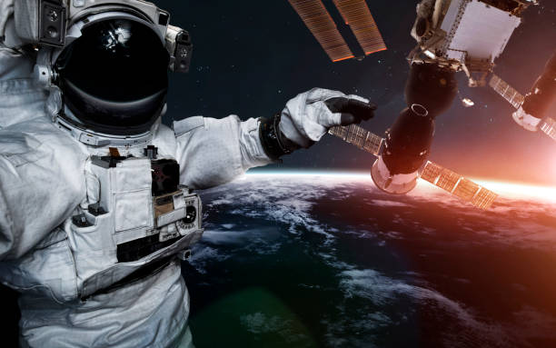 istock Astronaut at spacewalk against international space station. Science fiction art. Elements of this image furnished by NASA 1160659496