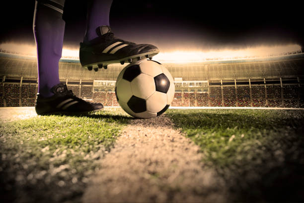 istock Foot on soccer ball mid field line 1160660624