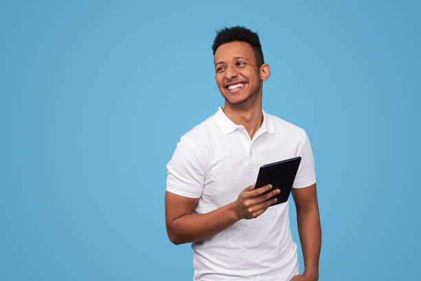 Laughing African male with tablet looking away