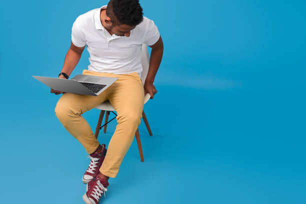istock Black guy with laptop sitting on chair 1160660830