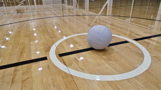 une boule de netball placée dans le cercle central d'un court intérieur de netball - indoor court photos et images de collection