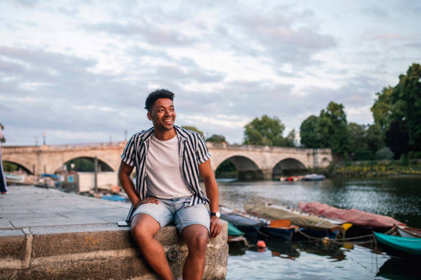 istock Relaxed Mixed Race Man Sitting on Embankment in Richmond 1160667281