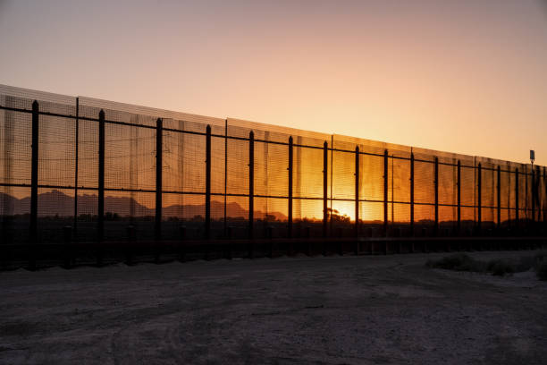 The International Border Wall Near Socorro, Texas and Ciudad Juarez, Mexico A view of the Border fence-like wall between the United States and Mexico in the early evening and sundown international border barrier stock pictures, royalty-free photos & images