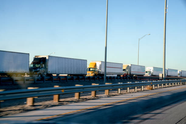A Long Line Of Semi Trucks Waiting To Cross The Border From The United States Into Mexico A long line of Semi Trucks waiting at the US side of the International Border crossing into Mexico to transport goods international border photos stock pictures, royalty-free photos & images