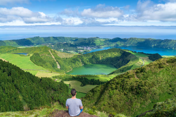 Young man at Sete Cidades lake in The Azores Young man at Sete Cidades lake in The Azores sao miguel azores stock pictures, royalty-free photos & images