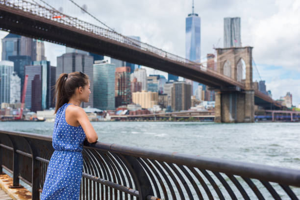 New York city urban tourist woman looking at Brooklyn bridge and skyline stock photo