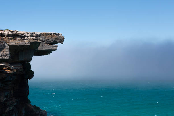 Eagle Rock and the mysterious sea fog Eagle Rock and a mysterious sea fog hung around all morning and drifting in land and out to sea several times..  Royal National Park, Sydney eagle rock stock pictures, royalty-free photos & images