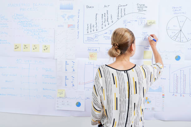 istock Businesswoman drawing charts on wall 1160693769
