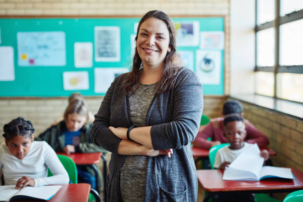 Lets learn something new today Shot of a confident young woman teaching a class of young children at school instructor stock pictures, royalty-free photos & images
