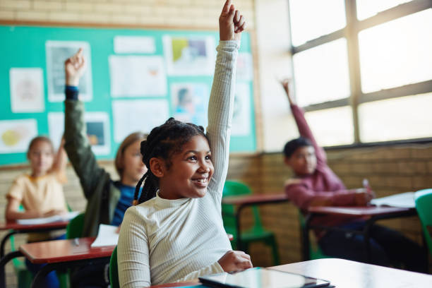 The more you know, the more you grow Shot of young children raising their hands in a classroom hand raised stock pictures, royalty-free photos & images