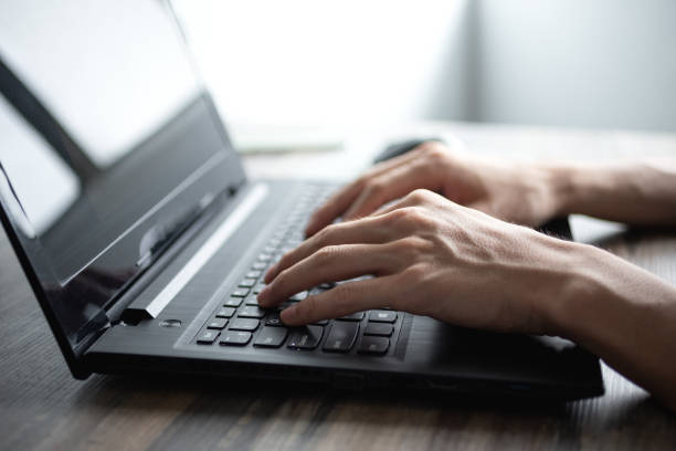 istock Male hands typing on black laptop computer keyboard 1160694908
