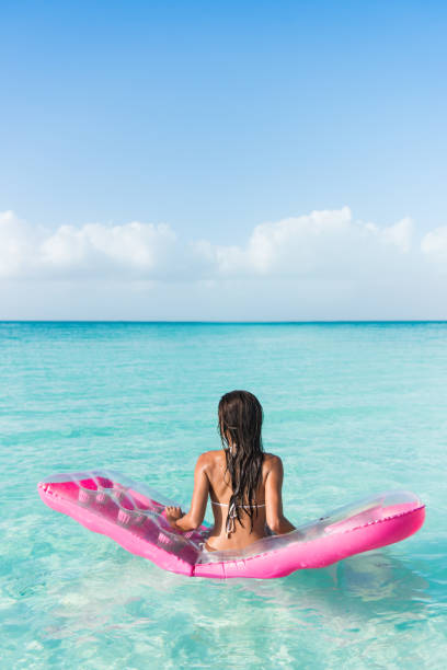 beach vacation woman relaxing on an ocean mattress - inflatable raft nautical vessel sea inflatable imagens e fotografias de stock