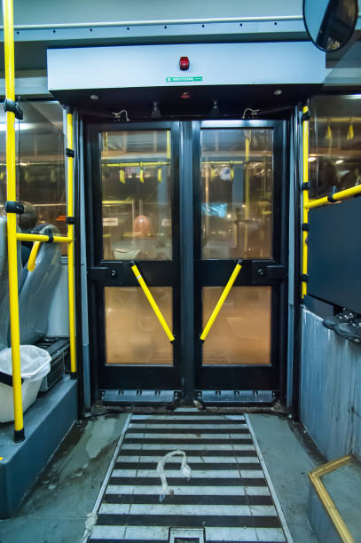 una puerta de autobús con asas amarillas vistas desde el interior. - bus door fotografías e imágenes de stock