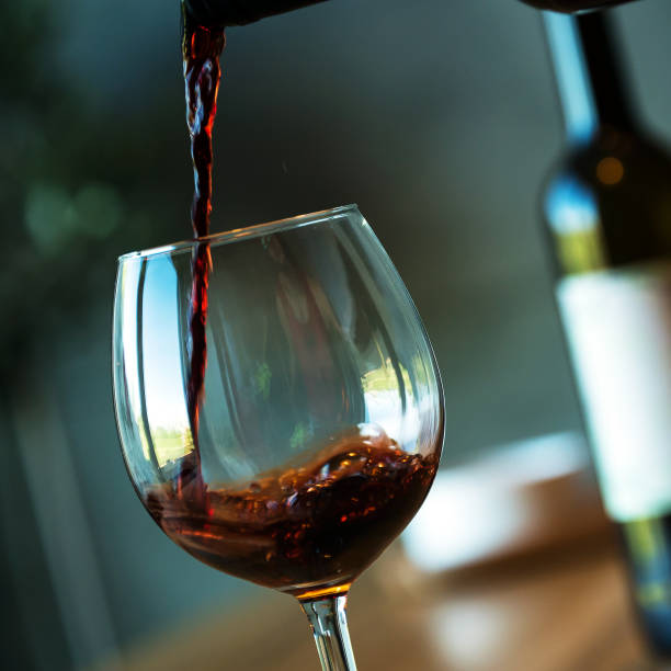 istock Pouring red wine on a wooden oak table 1160698793