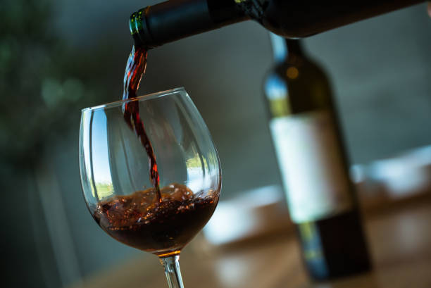istock Pouring red wine on a wooden oak table 1160698973