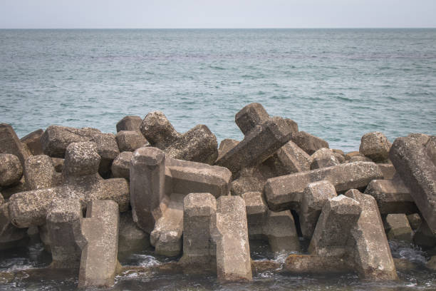 istock Breakwater coastal protection constructed from prefabricated cement blocks to reduce the intensity of wave action in inshore waters and thereby reduce coastal erosion or provide safe. 1160699045