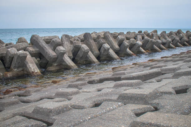 istock Breakwater coastal protection constructed from prefabricated cement blocks to reduce the intensity of wave action in inshore waters and thereby reduce coastal erosion or provide safe. 1160699062