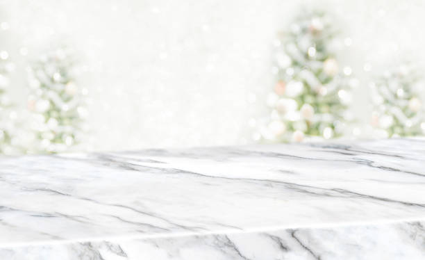 istock christams blur background,White marble table top at blur bokeh christmas tree decor with string light background when show falling,Winter holiday greeting card 1160699077