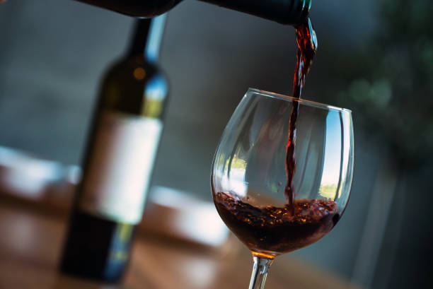 istock Pouring red wine on a wooden oak table 1160699097