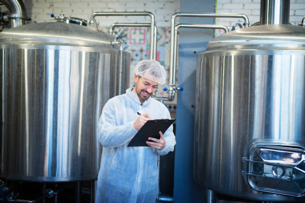 istock Smiling technologist taking notes in factory production line satisfied with the results. 1160699215