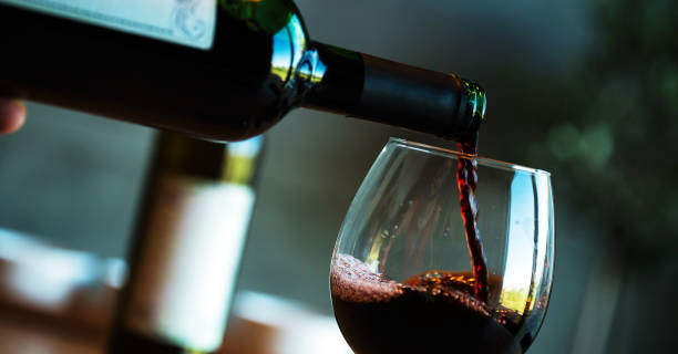 istock Pouring red wine on a wooden oak table 1160699347