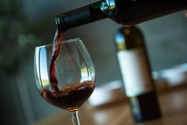 istock Pouring red wine on a wooden oak table 1160699971